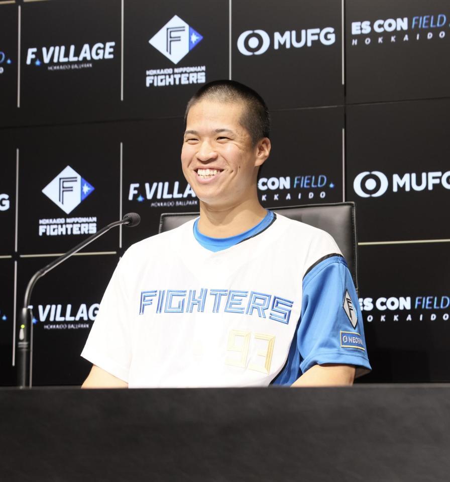 　支配下登録され、会見で笑顔を見せる松岡（撮影・中島達哉）