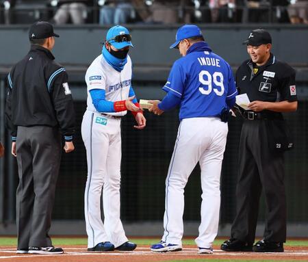 　メンバー表交換の際に新庄監督（中央）に「きよめぱん」を渡す井上監督（９９）＝撮影・中島達哉