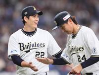 　５回、桑原を併殺打に打ち取り、紅林（右）とタッチを交わす九里（撮影・立川洋一郎）