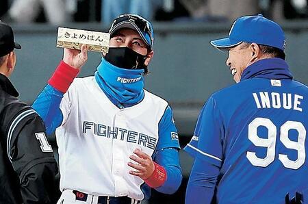 　メンバー表を交換し、井上監督（右）から「きよめぱん」をもらい、笑顔を見せる新庄監督（９日）