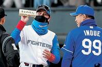 　メンバー表を交換し、井上監督（右）から「きよめぱん」をもらい、笑顔を見せる新庄監督（９日）