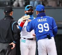 　メンバー表交換の際に井上監督（右）から「きよめぱん」を受け取る新庄監督（中央）＝撮影・中島達哉