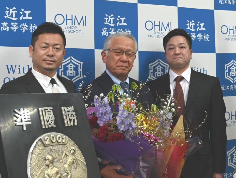 　ＯＢで元プロ野球選手の村西辰彦さん（左）と島脇信也さん（右）から花束を受け取った近江の多賀監督