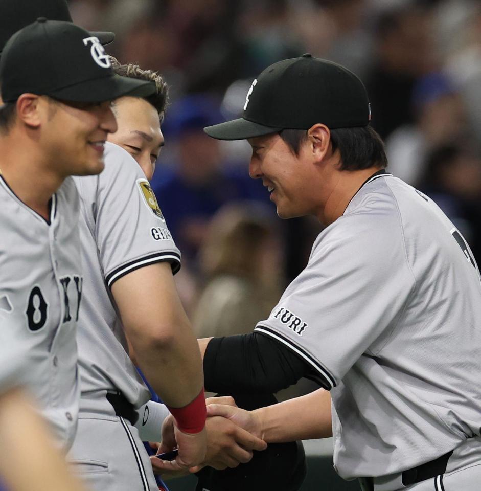 　長野と握手をする鈴木（撮影・佐々木彰尚）