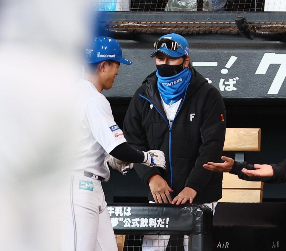 　２回、同点犠飛を放った今川（左）を迎える新庄監督（撮影・中島達哉）