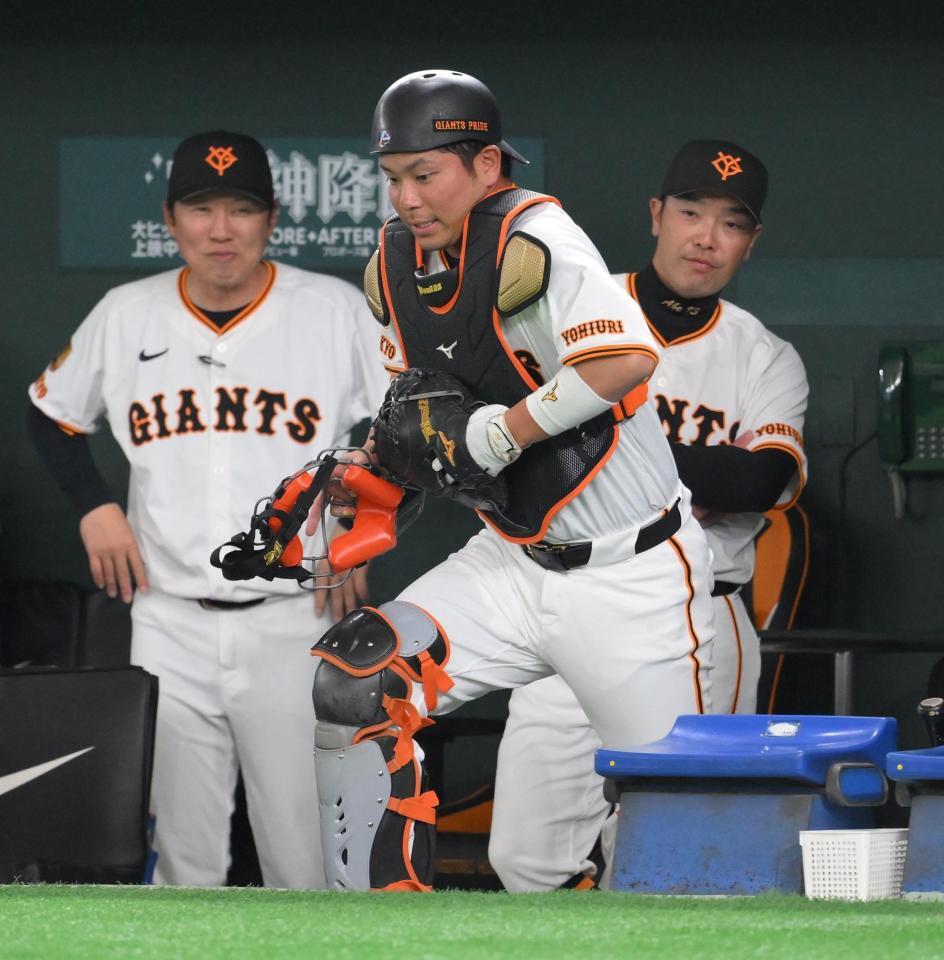 　５回、投手交代時にプロテクターを交換し再びグラウンドへ向かう大城卓（中央）。奥は村田善則バッテリーコーチと阿部監督（撮影・伊藤笙子）