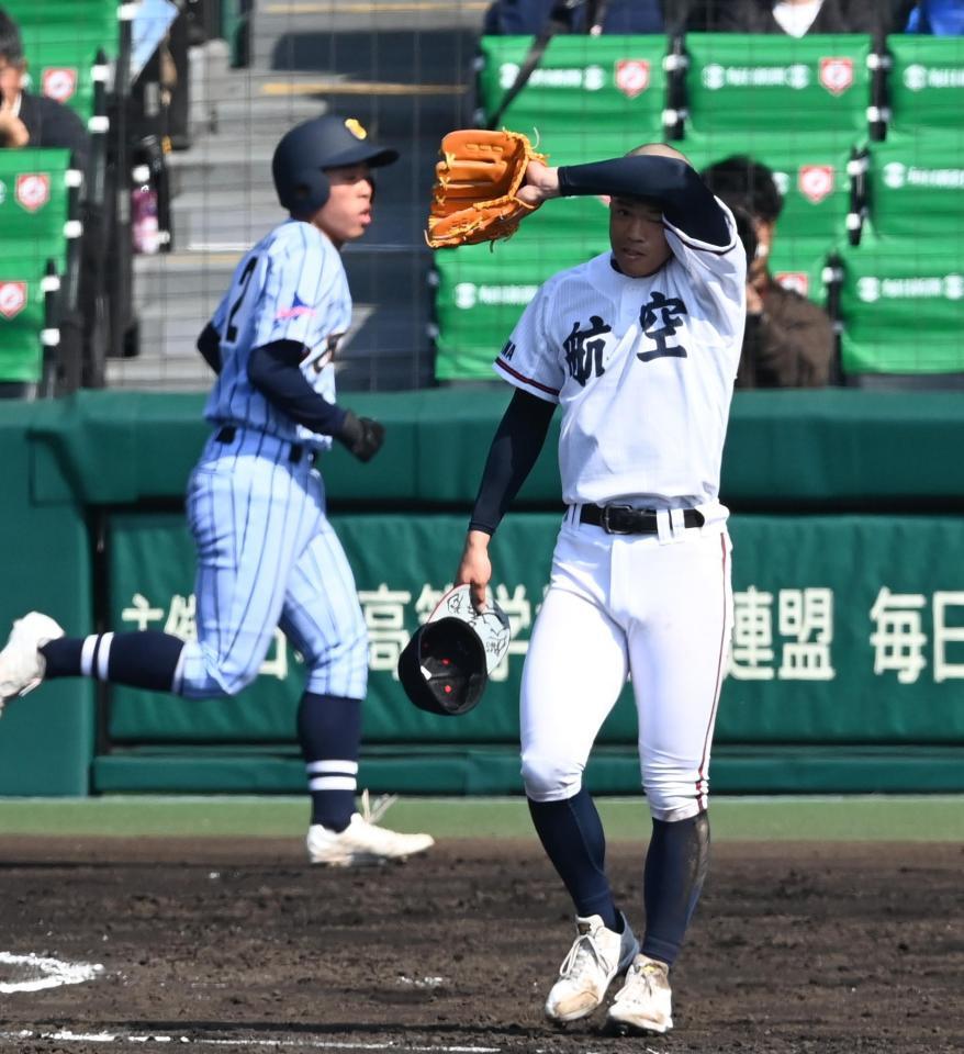 　３回、逆転三塁打を許して汗をぬぐう日本航空石川・蜂谷（右）