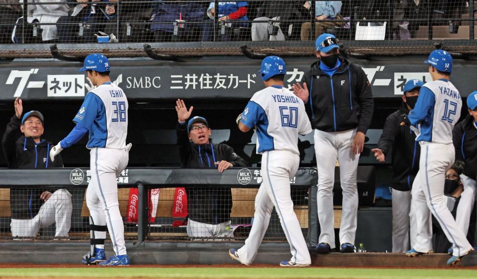 　８回、勝ち越し３ランを放った石井（左から２人目）らを迎える新庄監督（右から４人目）＝撮影・中島達哉