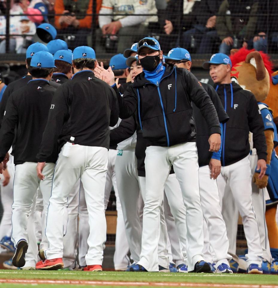 　ヤクルトに勝利をあげ、伊藤（左）らナインを迎える新庄監督（中央）＝撮影・中島達哉