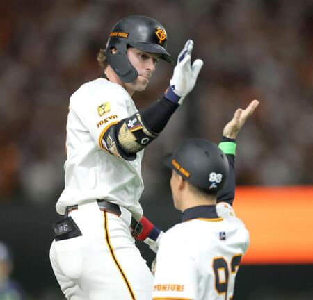 　８回、２ランを放ち、松本コーチ（右）とタッチを交わすキャベッジ（撮影・西岡正）