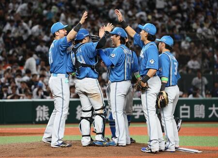 　開幕戦で勝利をあげ、タッチを交わす清宮幸（左）ら日本ハムナイン（撮影・中島達哉）