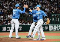 　開幕戦で完封勝利をあげた金村（左）とタッチを交わす清宮幸