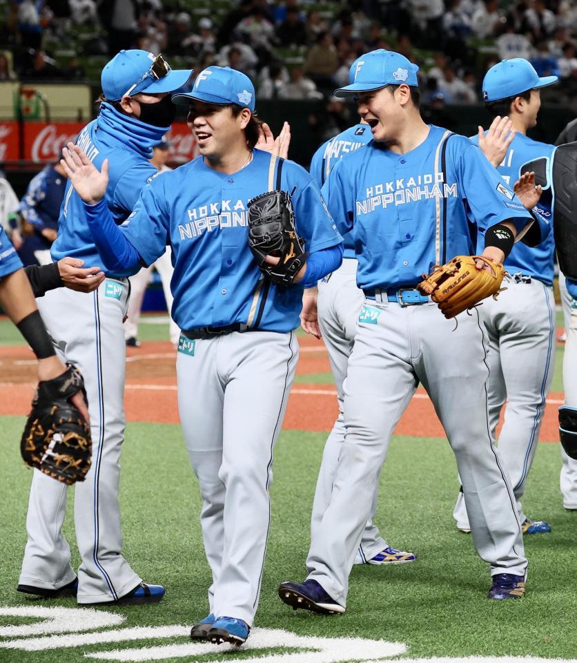 　開幕戦で勝利をあげ、金村（左から２人目）、清宮幸（中央右）らを迎える新庄監督（左）