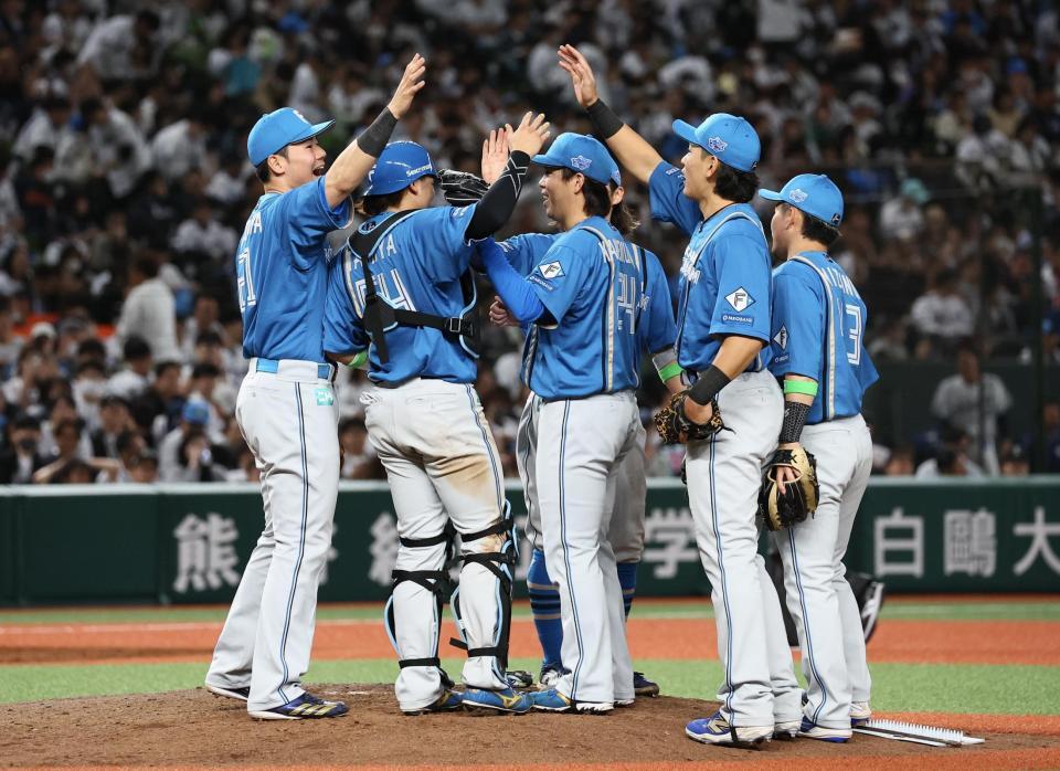 　開幕戦で勝利をあげ、タッチを交わす清宮幸（左）ら日本ハムナイン（撮影・中島達哉）