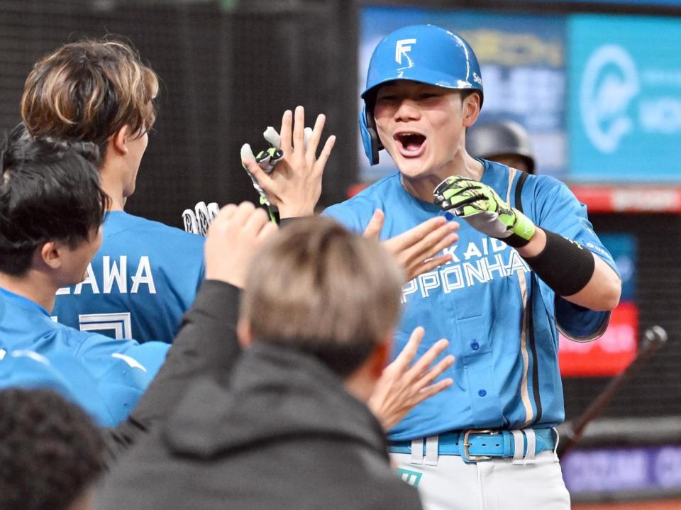 　７回、先制ソロを放ち、ナインに迎えられる清宮幸