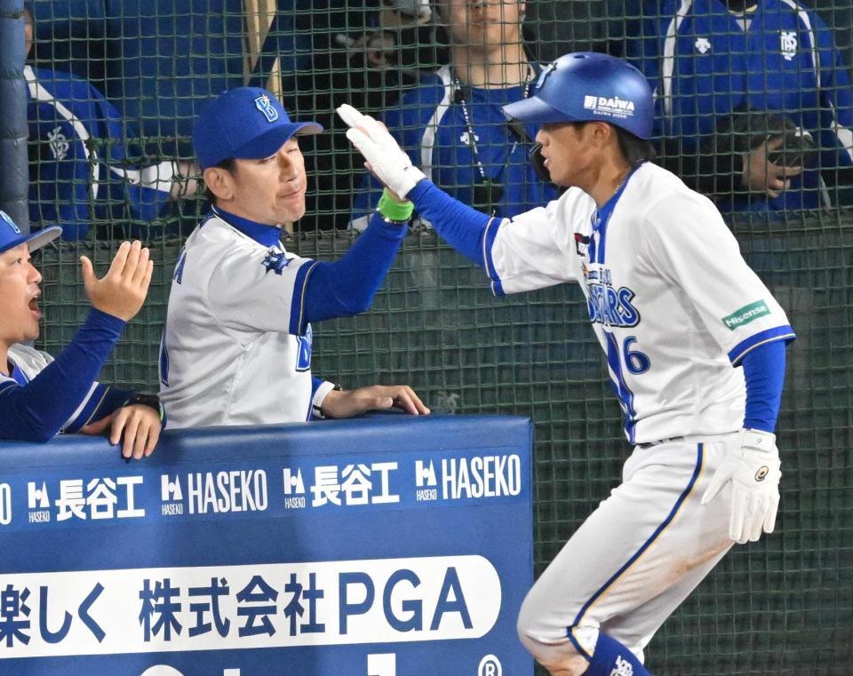 　５回、梶原の適時打で生還した森敬（右）とタッチを交わす三浦監督