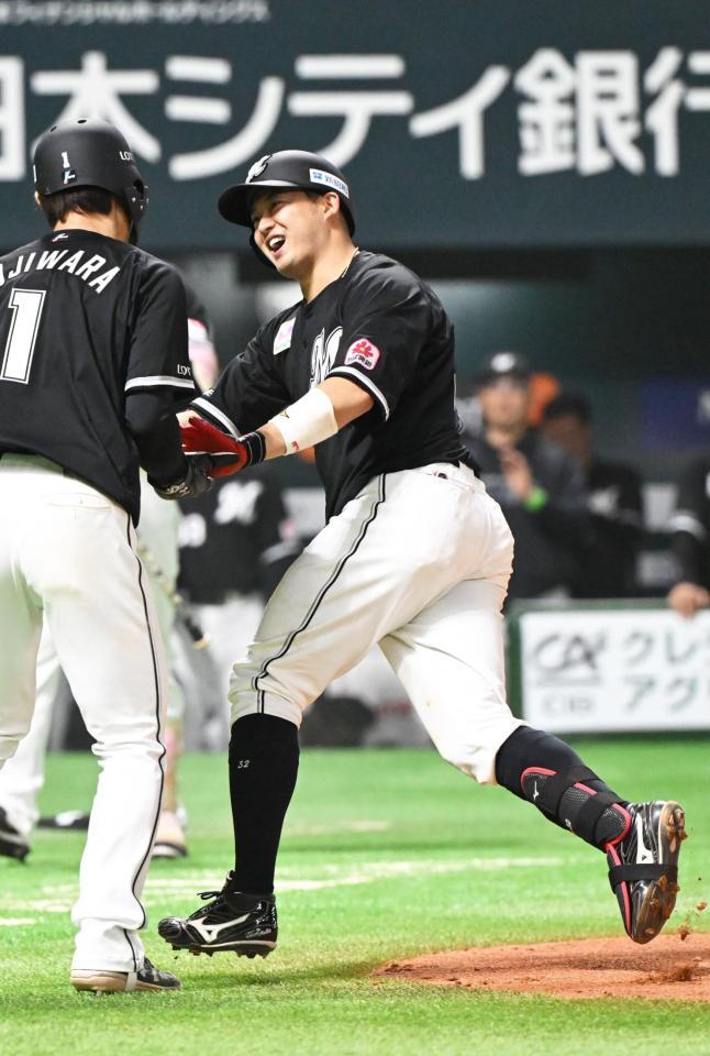 　６回、２ランを放ち、藤原とタッチを交わす佐藤（右）