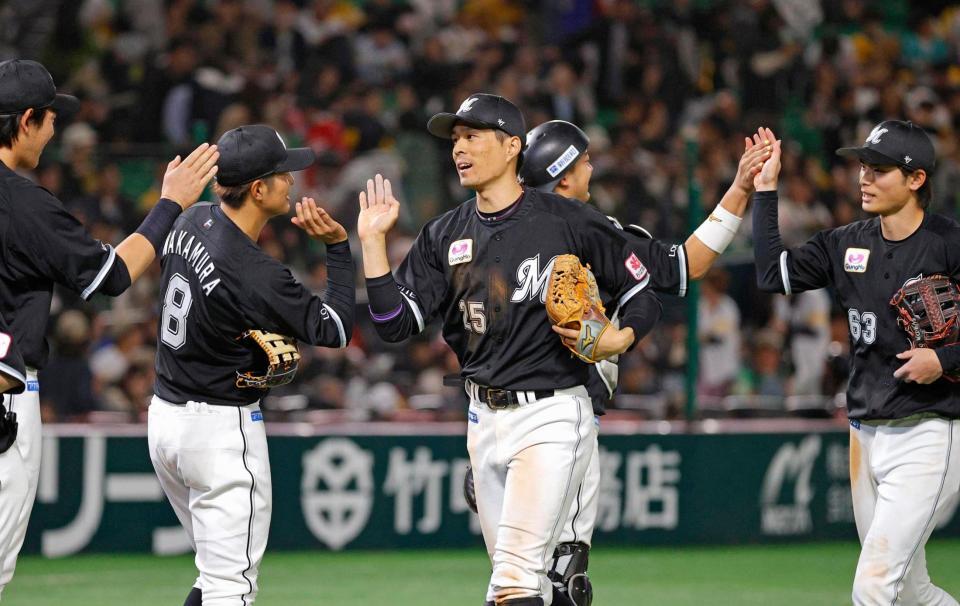 　ソフトバンクに勝利しタッチする岡（中央）らロッテナイン