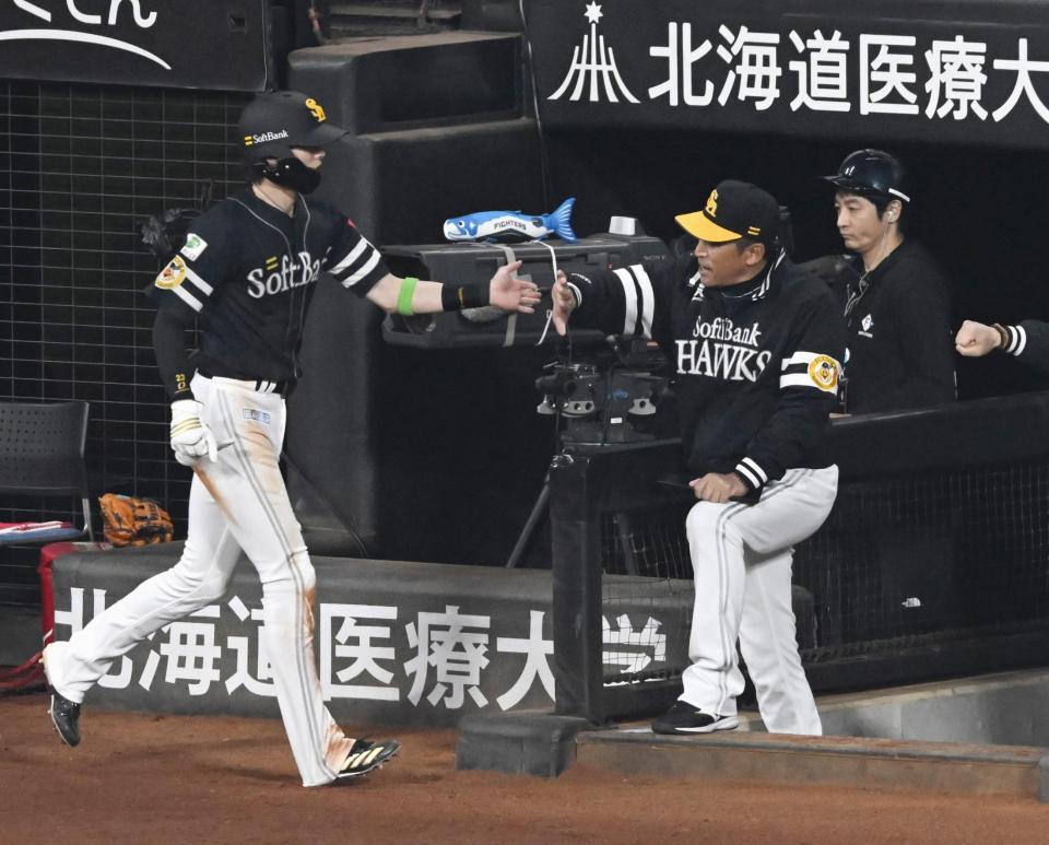 　１回、柳田の右前打で生還した周東（左）を迎えるソフトバンク・小久保監督＝エスコンフィールド