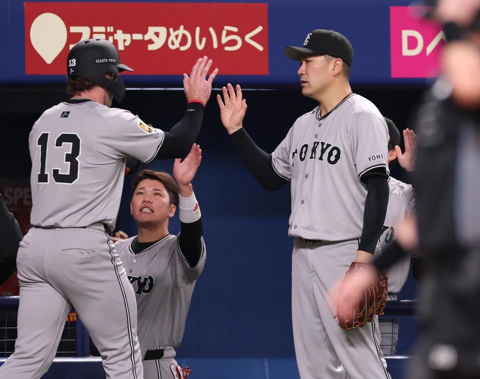 　３回、生還したキャベッジ（左）とタッチを交わす田中将