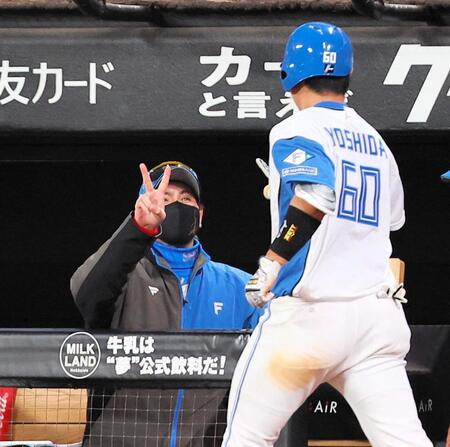 　６回、ソロを放った吉田（右）を迎える新庄監督（撮影・中島達哉）