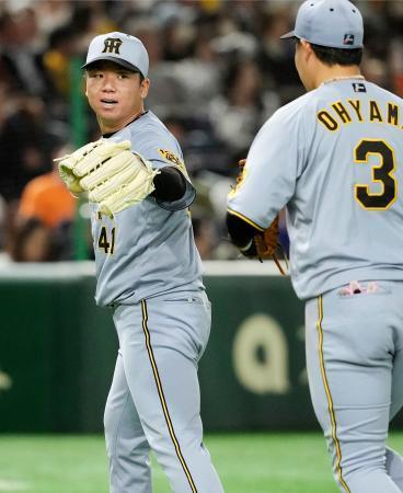 　７回を投げ終え一塁手大山（手前）とタッチを交わす阪神先発の村上＝東京ドーム