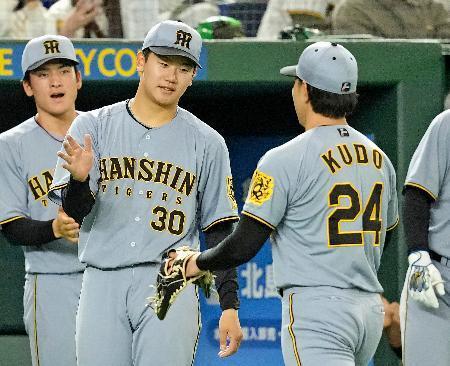 　６回、ピンチを切り抜けベンチに戻る工藤（右）を迎える阪神・門別＝東京ドーム