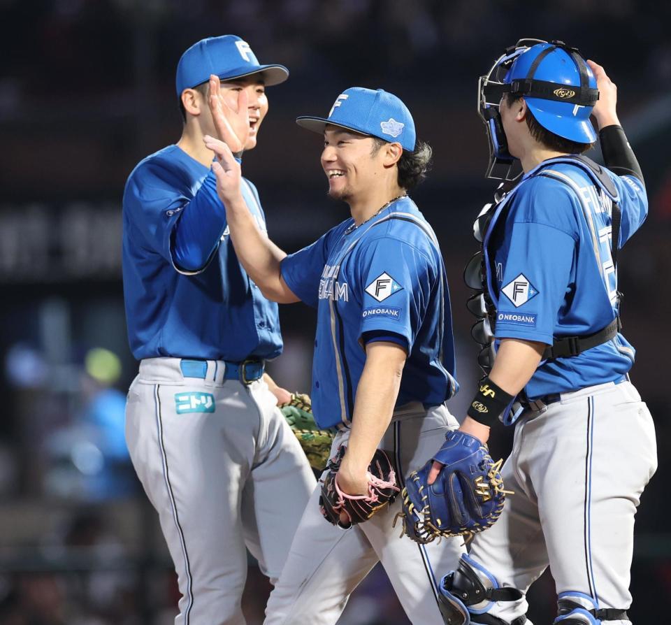 　完投勝利を挙げ決勝打の清宮幸と笑顔でタッチを交わす伊藤（撮影・金田祐二）