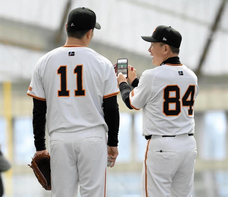 　田中将（左）にスマートフォンで撮影した動画を見せる久保コーチ