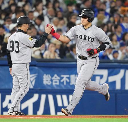 　４回、本塁打を放ち三塁コーチとタッチを交わす巨人・岡本＝横浜