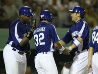 　現役時代に本塁打を放ってブランコ氏（左）から迎えられる森野打撃・作戦コーチ（右）＝２０１０年７月