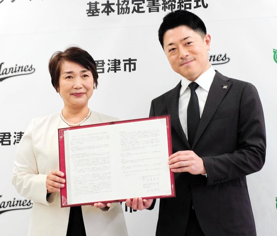 　２軍本拠地移転に関する「基本協定書」を手にするロッテ・高坂社長（右）と君津市・石井市長