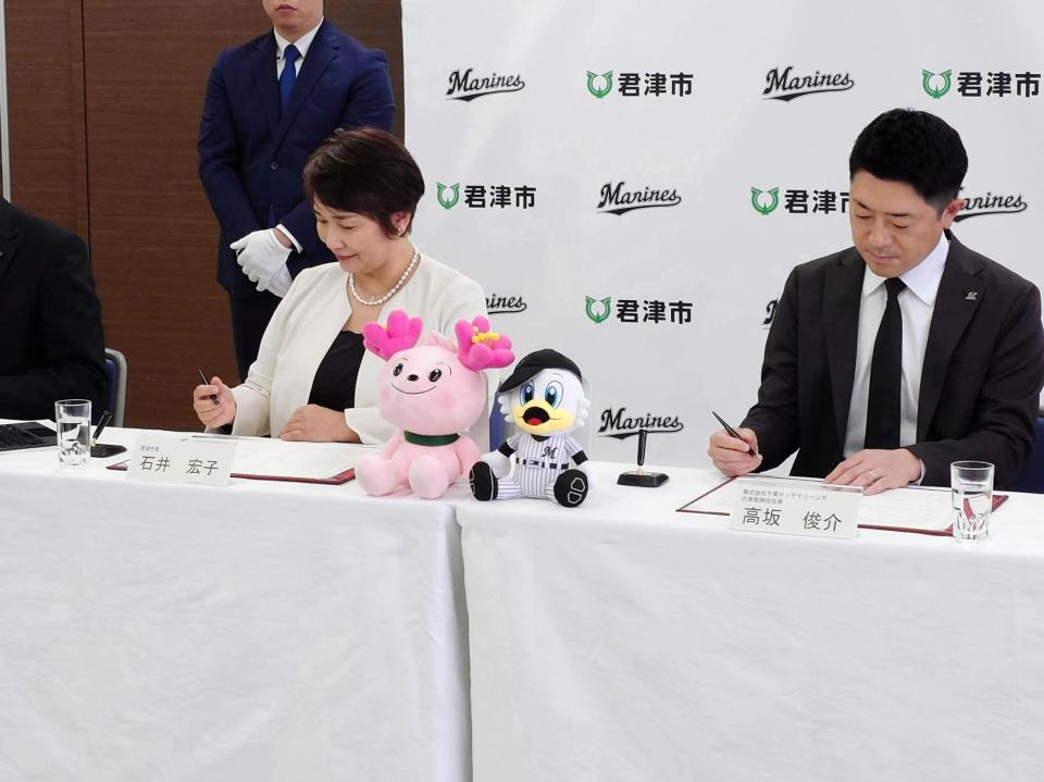 　２軍本拠地移転に関する「基本協定書」にサインするロッテ・高坂社長（右）と石井市長