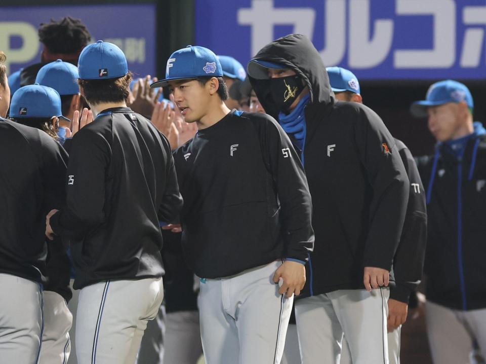 　ナインを迎える新庄監督と北山（撮影・金田祐二）