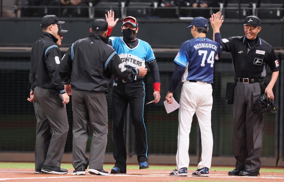 　西口監督（右から２人目）や審判団とハイタッチを交わす新庄監督（中央）＝撮影・中島達哉