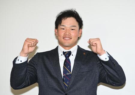 　支配下登録され会見でガッツポーズを決める山本（撮影・開出牧）