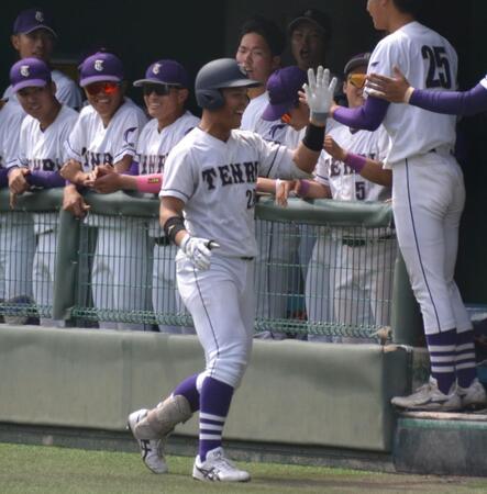 　２回、犠打を決めて仲間とハイタッチする天理大・関本