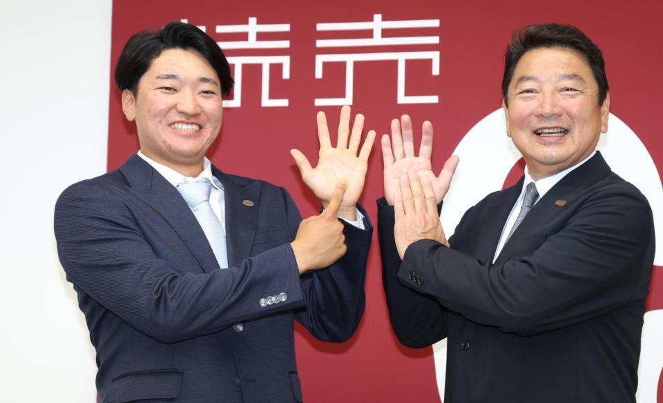 　支配下登録が決まり吉村禎章編成本部長と新背番号「６９」を指でつくる笹原（撮影・金田祐二）