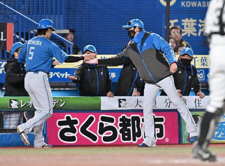　６回、石井の適時打で生還した三走野村を迎える新庄監督（右）