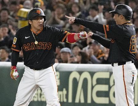 　３回、先制打を放ち、一塁コーチとタッチを交わす巨人・甲斐＝東京ドーム