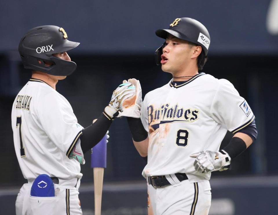 　１回、太田の二ゴロで生還し、西川（左）とタッチを交わす麦谷（撮影・立川洋一郎）