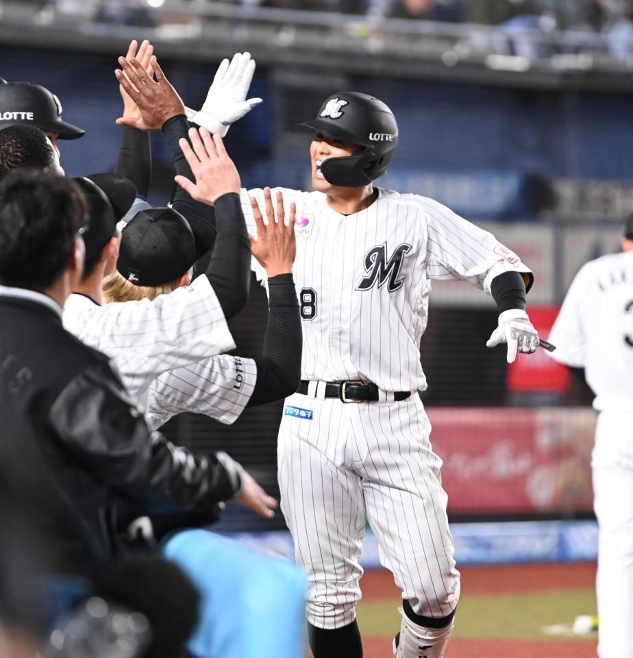 　８回、左越えソロを放ち、ナインとタッチを交わす中村奨（撮影・開出牧）