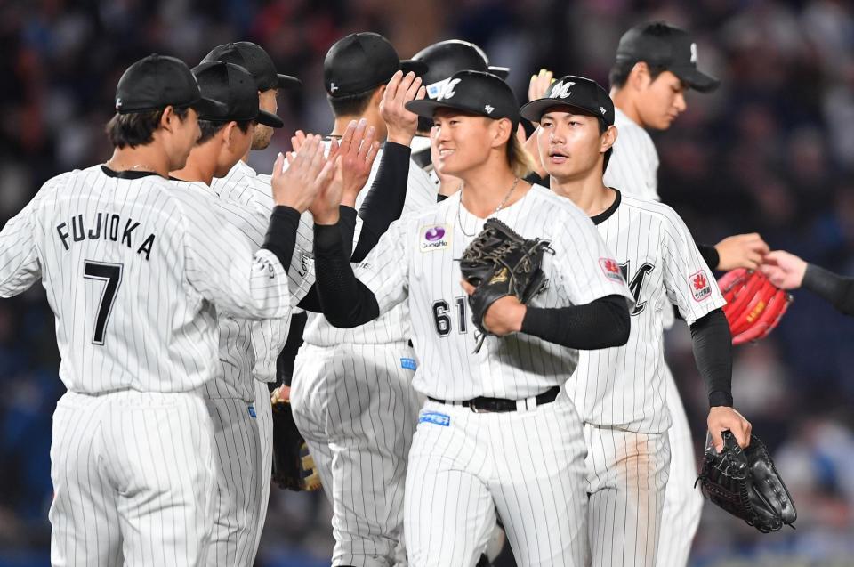 　日本ハムに圧勝しタッチを交わす山本（６１）らロッテナイン（撮影・開出牧）