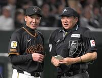 　５回裏終了後、笑みを浮かべながら有隅球審（右）に選手交代を告げる阿部監督（撮影・佐藤厚）