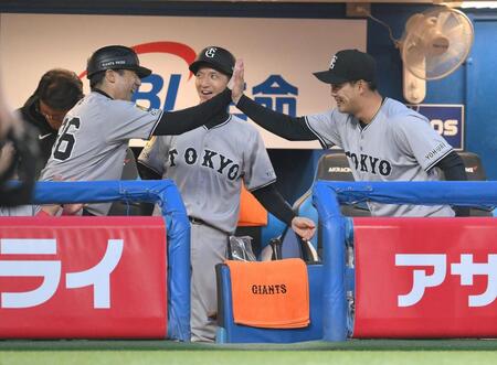 　１回、オスナの三ゴロで岡本の好プレーをお膳立てし、古城コーチ（右）とハイタッチする一塁手の荒巻（撮影・伊藤笙子）