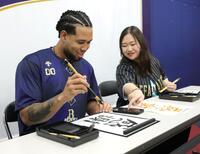 　オリ姫の松尾未知留（右）さんと書道に挑戦するエスピノーザ（撮影・坂部計介）