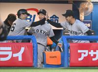 　１回、オスナの三ゴロで岡本の好プレーをお膳立てし、古城コーチ（右）とハイタッチする一塁手の荒巻（撮影・伊藤笙子）