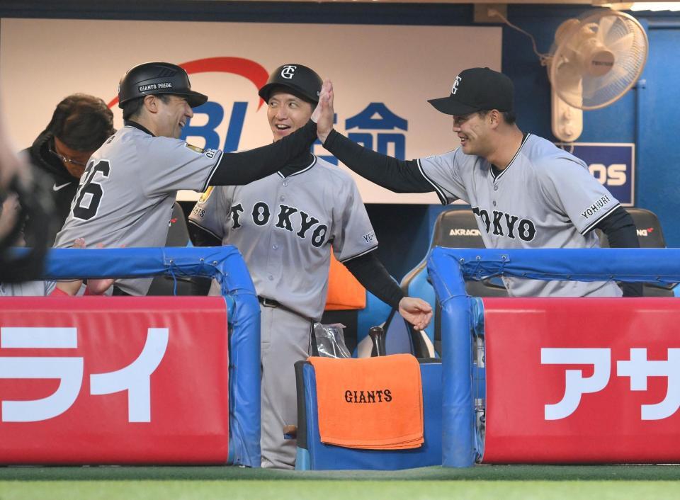 　１回、オスナの三ゴロで岡本の好プレーをお膳立てし、古城コーチ（右）とハイタッチする一塁手の荒巻（撮影・伊藤笙子）