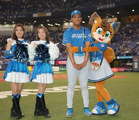 　日本ハムのマスコットキャラクター・ポリーポラレスに抱きつかれ、照れ笑いをする万波（撮影・坂部計介）