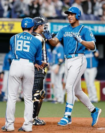 　８回、勝ち越し３ランを放ちコーチとタッチを交わす日本ハム・万波＝京セラドーム